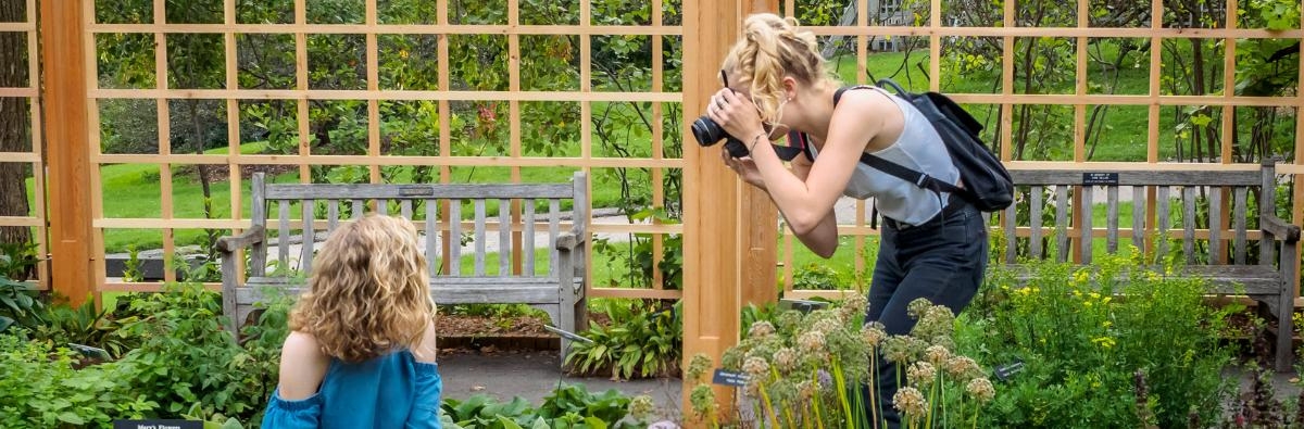Woman photographing girl in the gardens