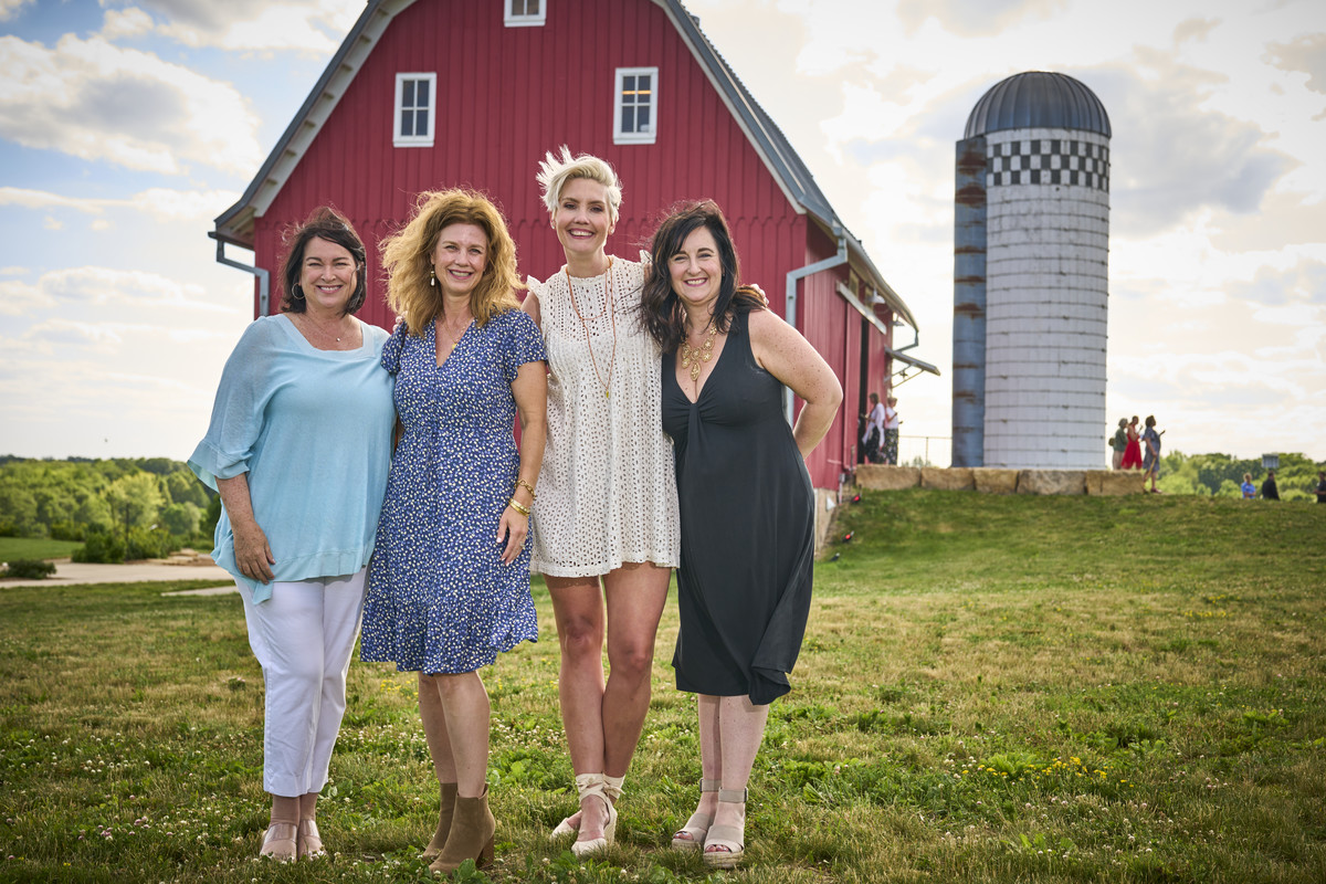 4 women in front of the red barn