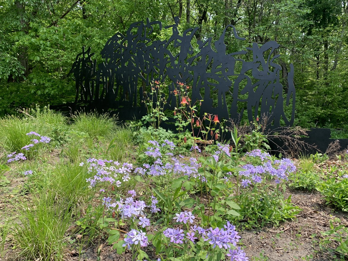 Wild Woods sculpture in the summer with flowers