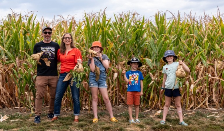 Family standing in front of corn